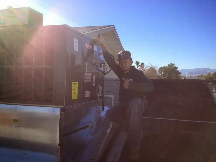HVAC technician performing Air Duct Cleaning on a rooftop unit in Economy